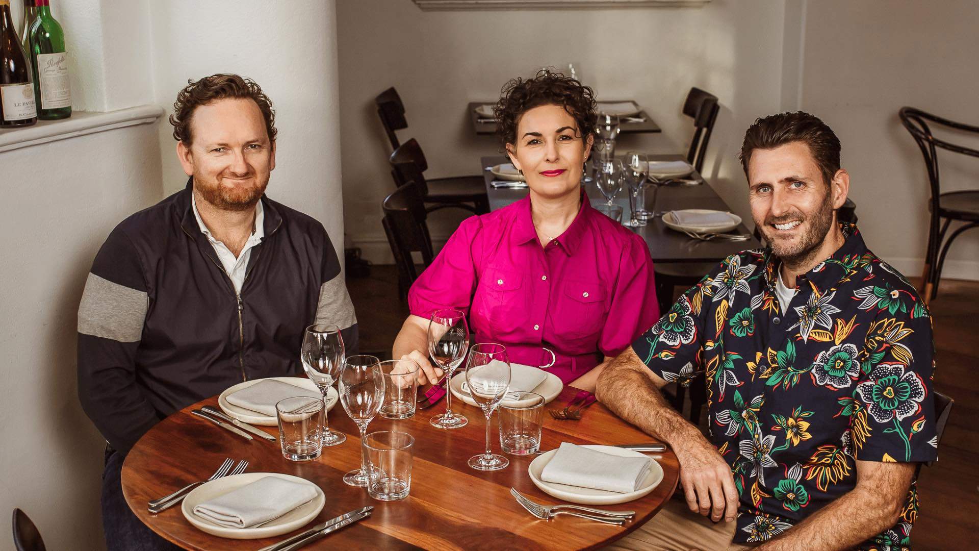 The co-founders of One Penny Red sitting at a dining table.