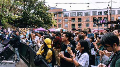 A crowd watching a stage outdoors.