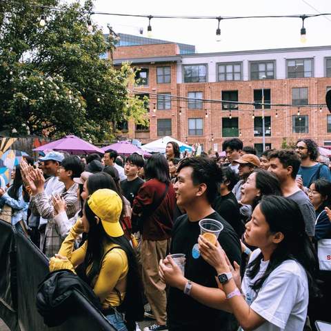 A crowd watching a stage outdoors.