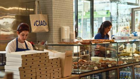 Two bakers working behind the counter at Fabbrica Brea Shop, Rozelle. Croissants and sandwiches can be seen ready to be ordered.