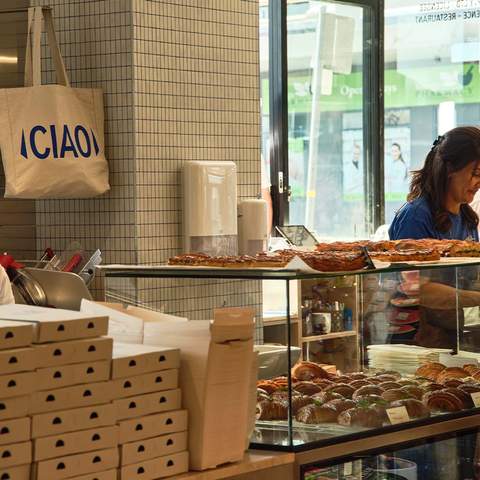 Two bakers working behind the counter at Fabbrica Brea Shop, Rozelle. Croissants and sandwiches can be seen ready to be ordered.