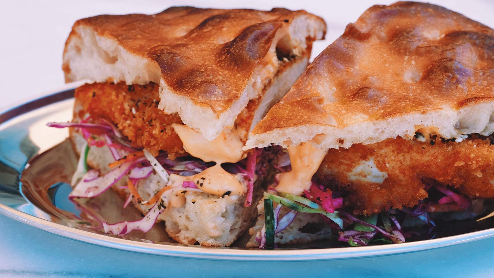 A loaded chicken schnitzel sandwich on thick focaccia