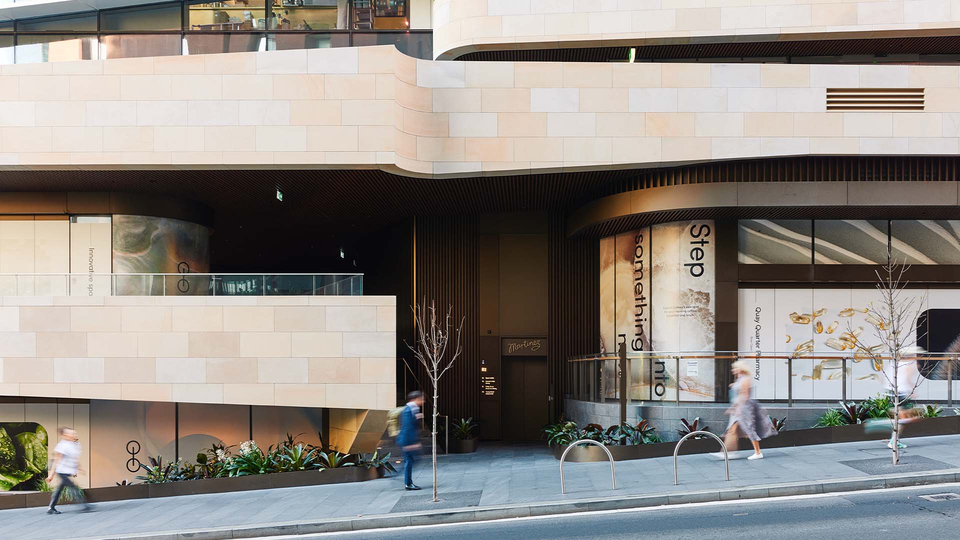 The facade of Sydney Place in Circular Quay with a suited city worker walking in front