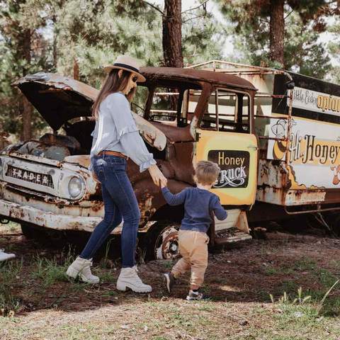 A family with a toddler in front of a honey truck.