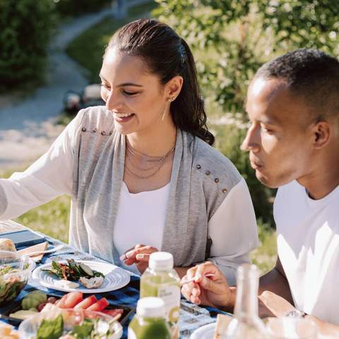 A couple having a picnic outdoors.