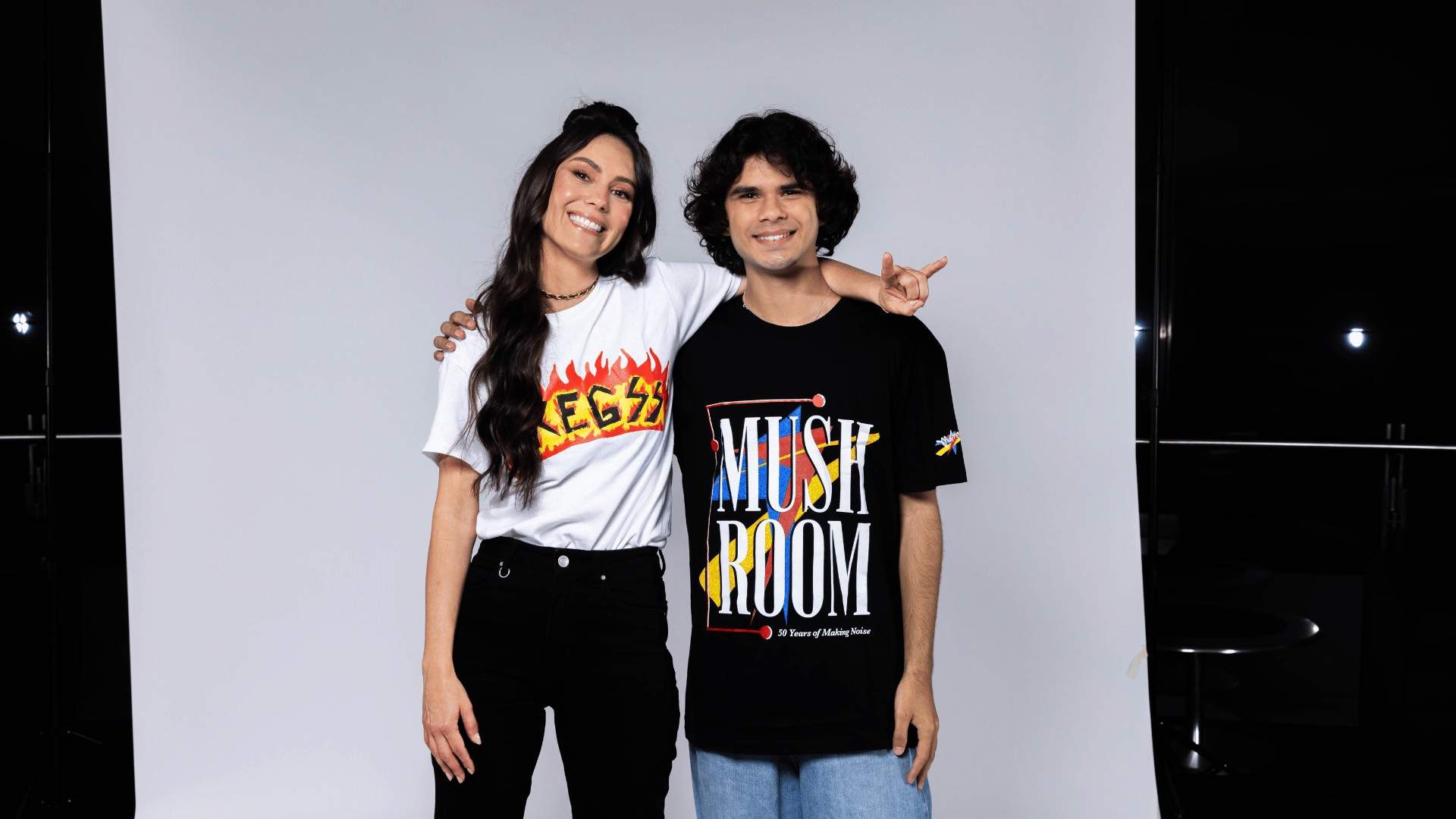 Amy Shark and Budjerah posing in front of a white backdrop.