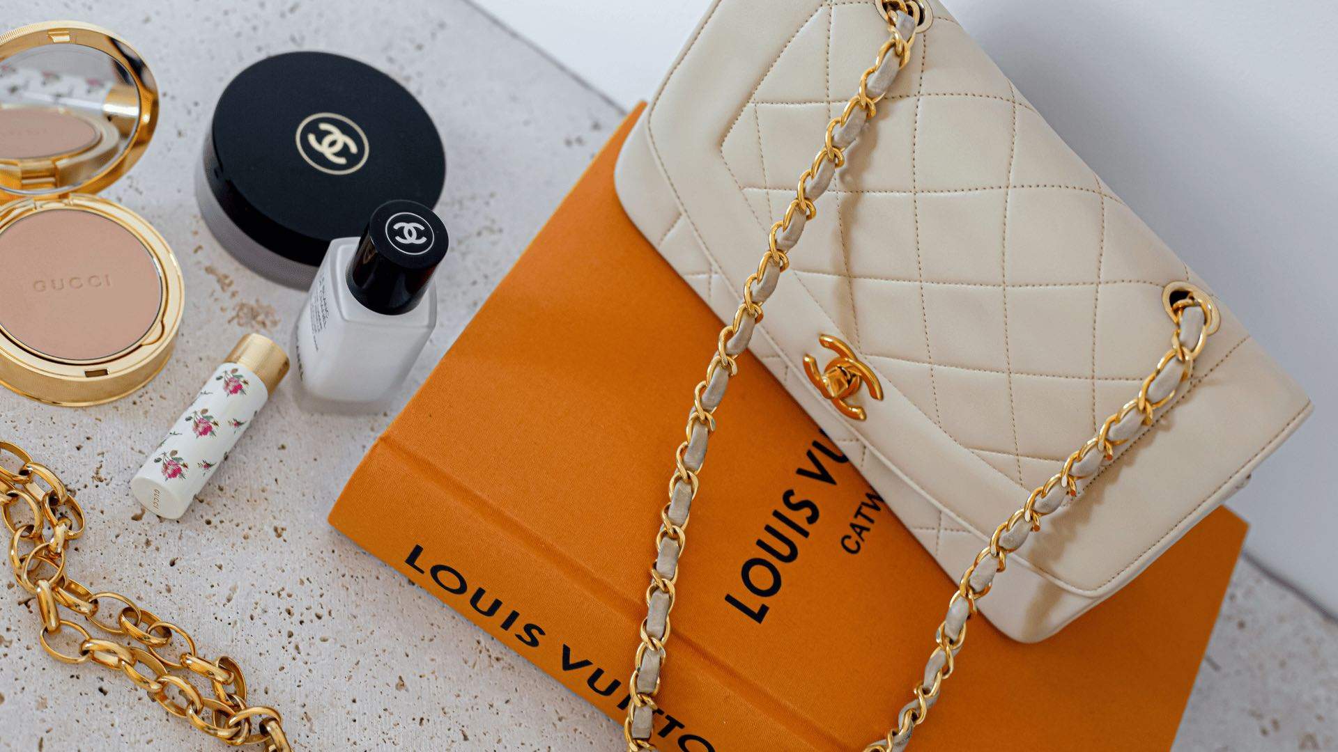 A Chanel bag on top of a Louis Vuitton coffee table book.