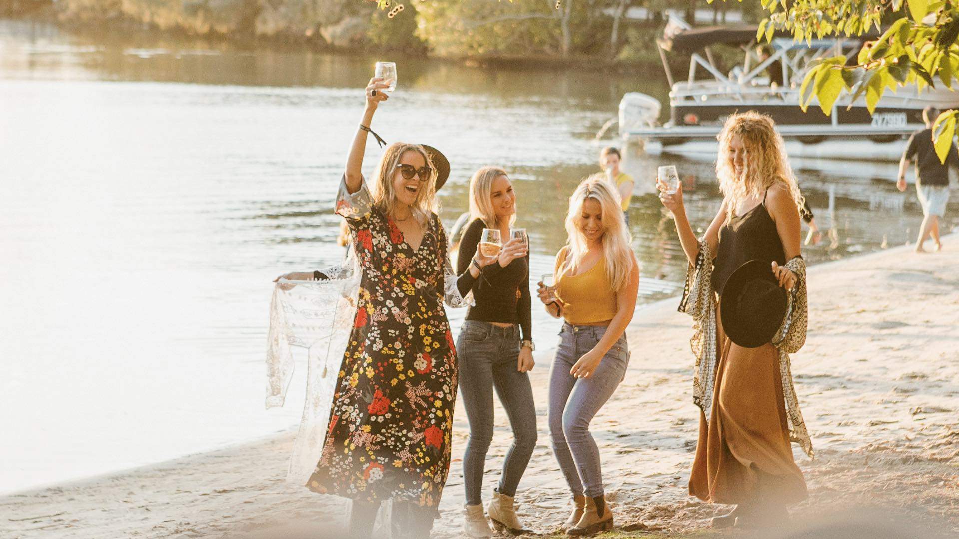Four women dancing on the beach at Noosa Eat and Drink Festival.