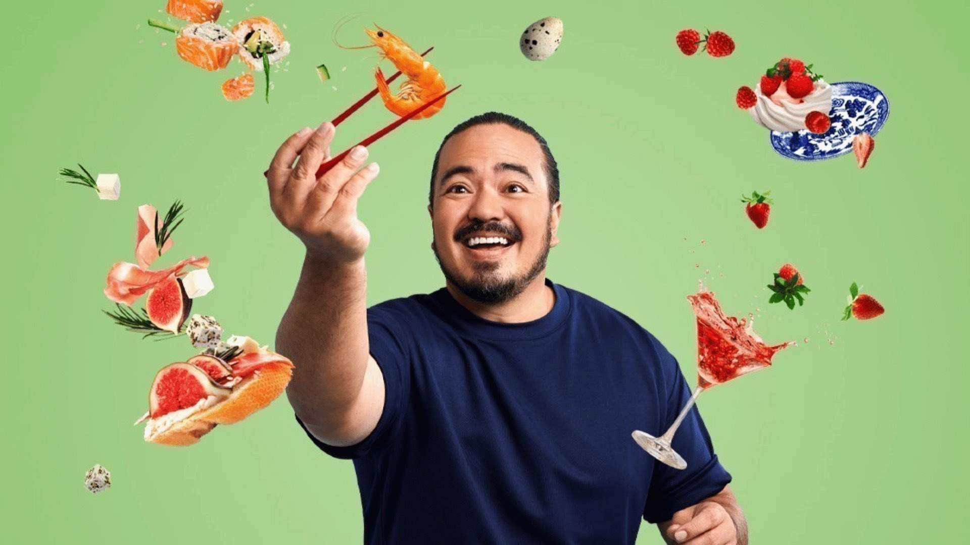 Adam Liaw in front of a green background with various food floating around him.