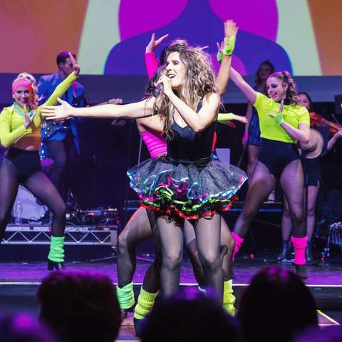 The 80s Ladies performing on stage.