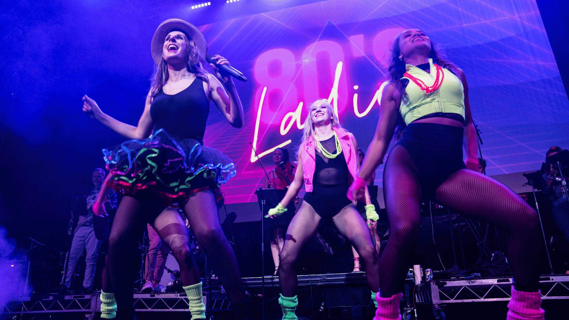 The 80s Ladies performing on stage.