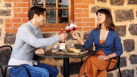 A couple enjoying a bottle of wine with charcuterie.