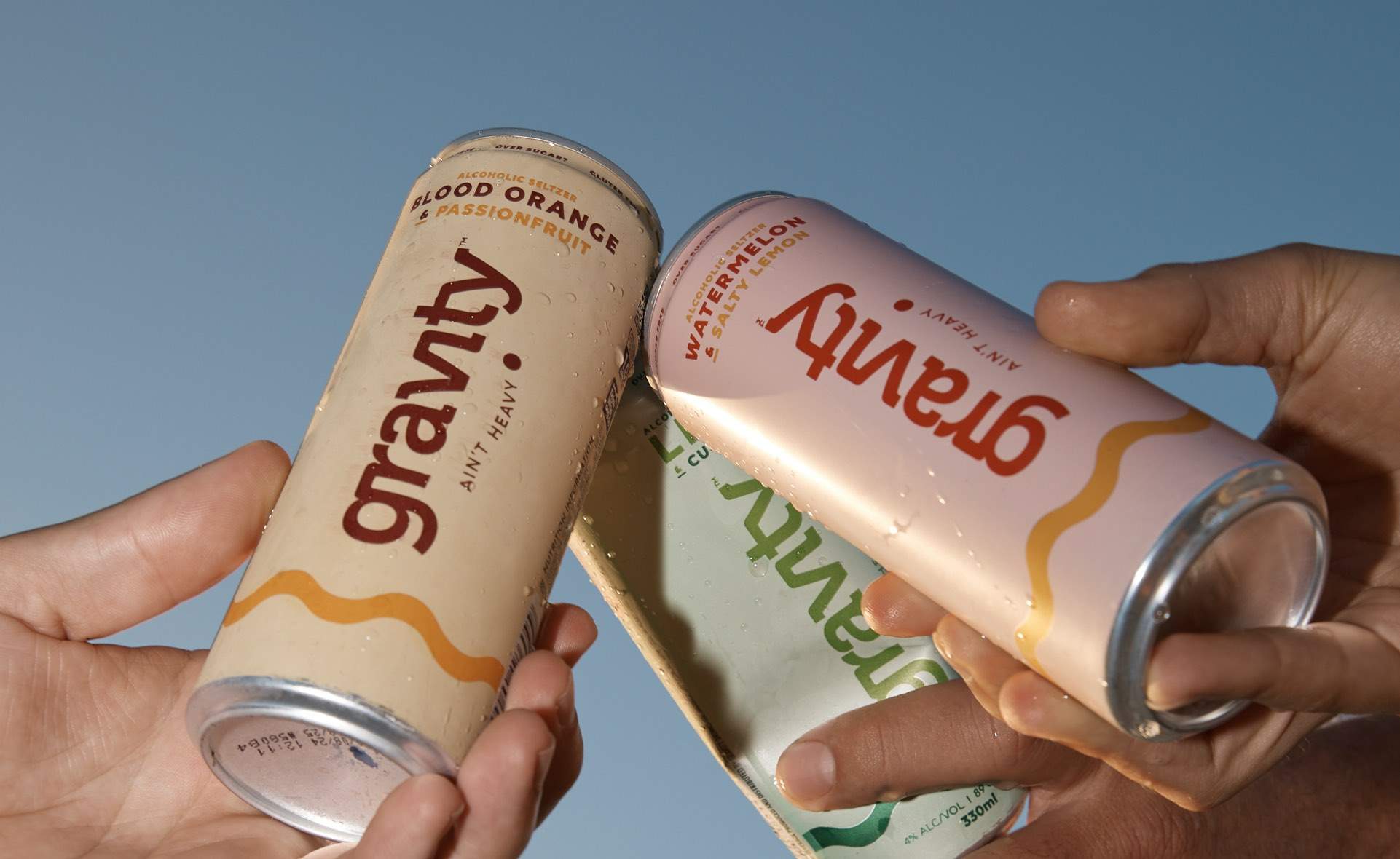 Three cans of Gravity Drinks premixed drinks meet together in a cheers