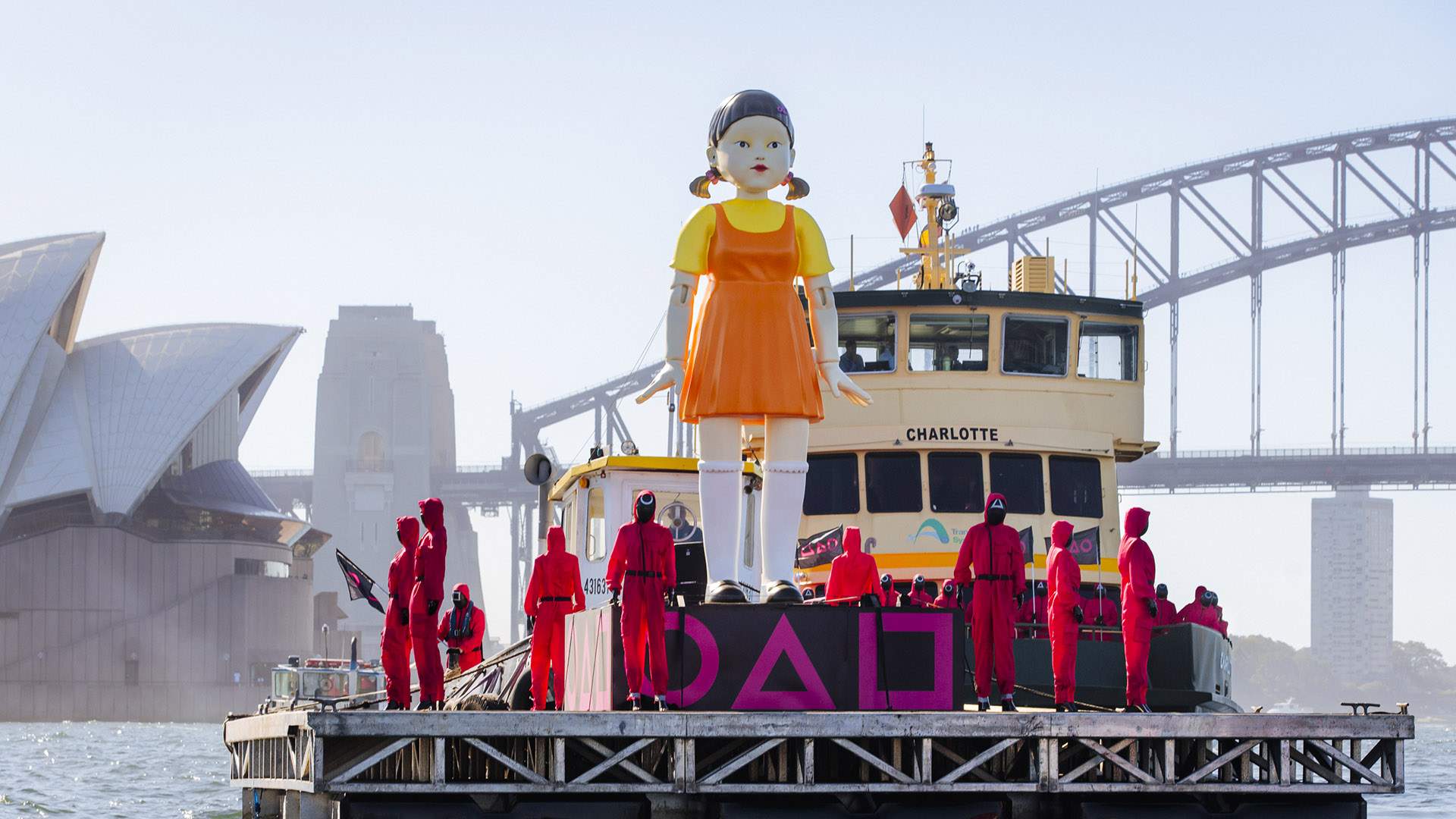 The 'Squid Game' 'Red Light, Green Light' Doll Is Back in Australia — and 300 Pink Guards Escorted It Across Sydney Harbour