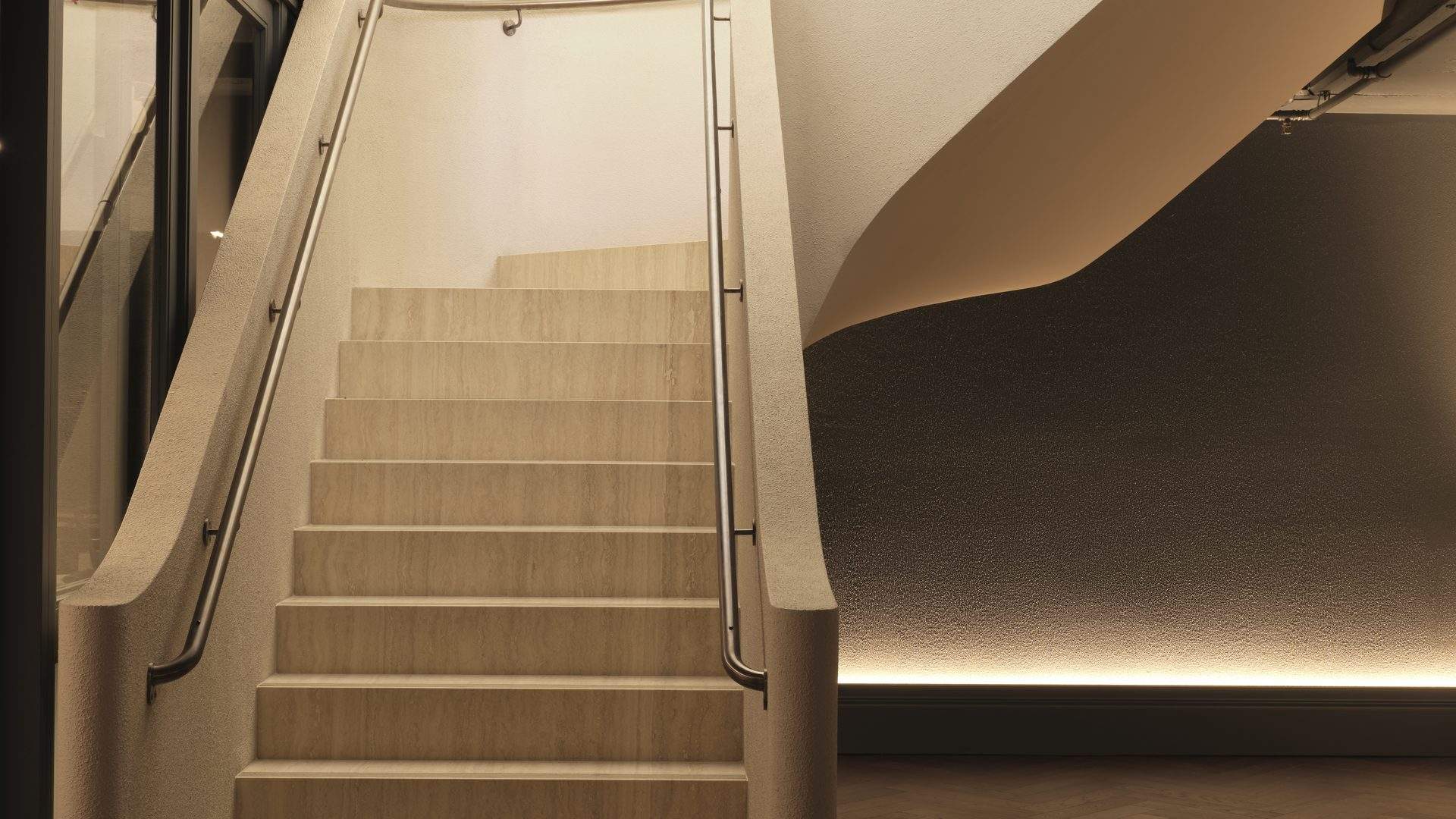 Travertine staircase with sculptural curved walls inside Bodylove Pilates Neutral Bay