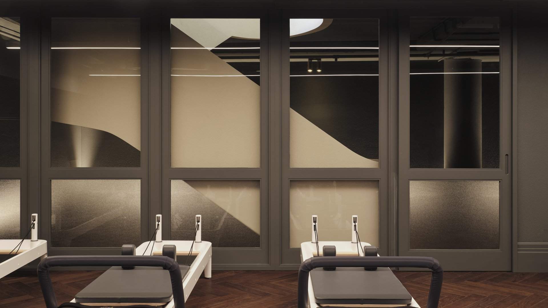 Reformer beds on walnut herringbone floors in the Bodylove Pilates Neutral Bay studio