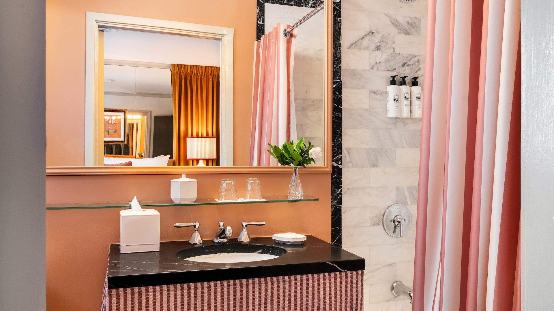 Striped, marble-tiled guest bathroom at The Hôtel Lili in Beverly Hills