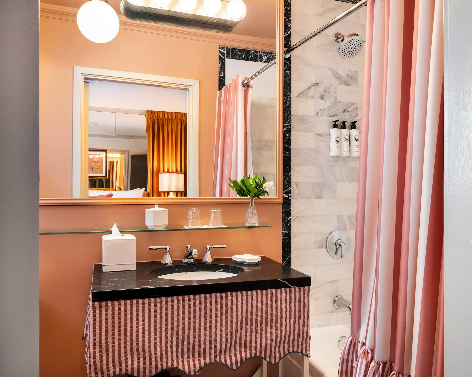 Striped, marble-tiled guest bathroom at The Hôtel Lili in Beverly Hills