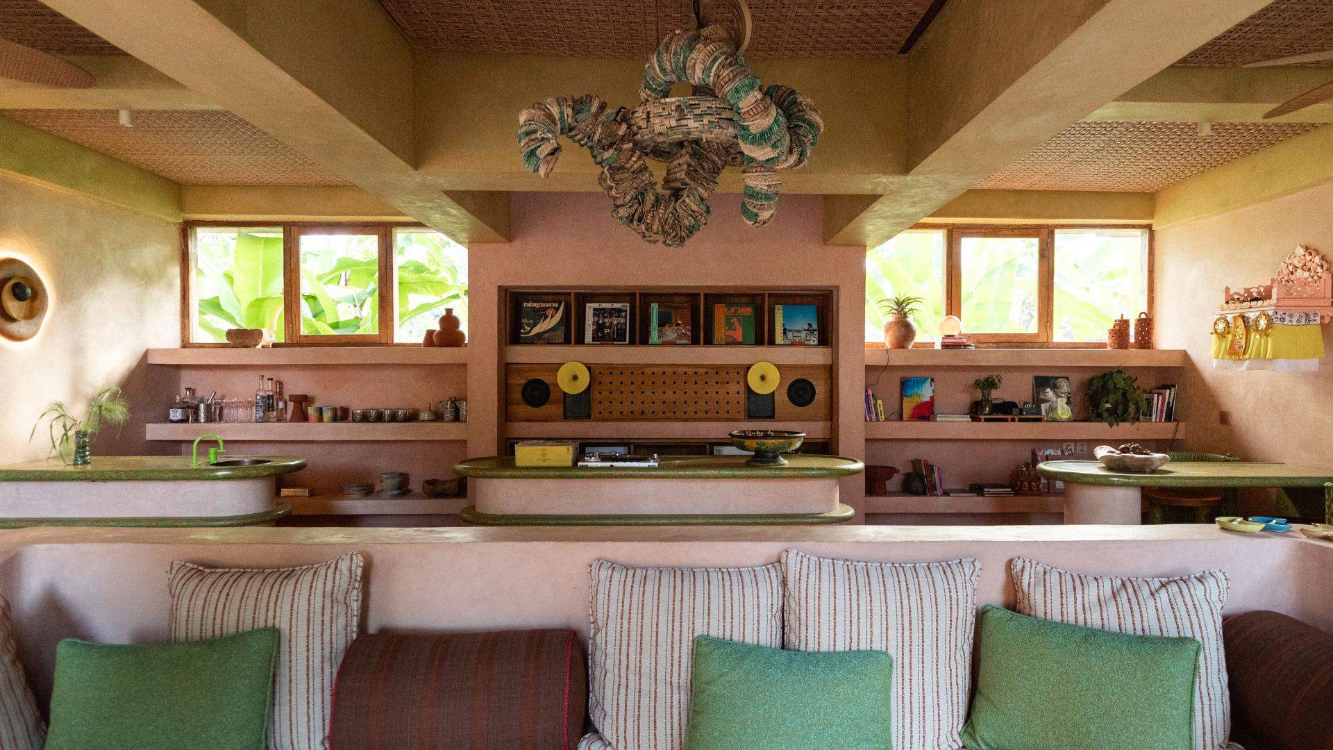 The Nongkrong Lounge at Moon Gang Ubud with striped cushions, built-in shelving and a sculptural light fitting
